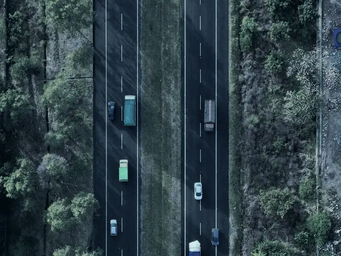 Vista aérea de un camión avanzando por una ruta entre el monte