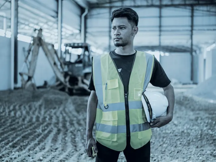 Trabajador con chaleco reflectivo y casco en una obra