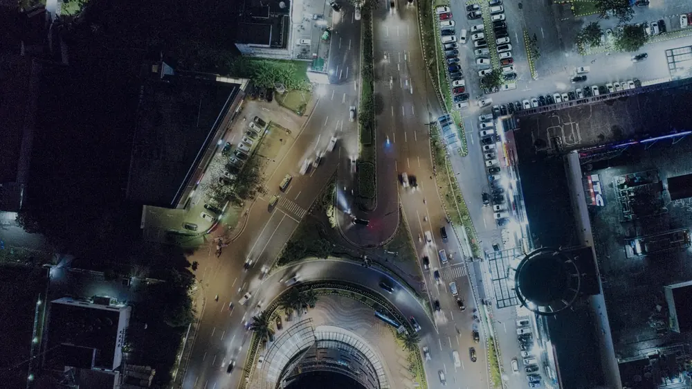 Vista aérea nocturna de una ciudad con el tránsito iluminado